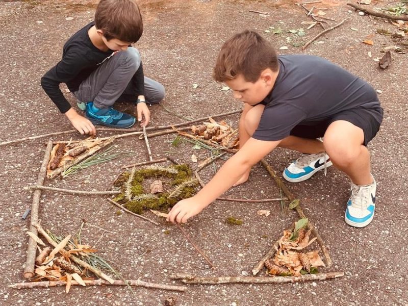 Kinder der 3a beim Legen eines Naturmandalas.