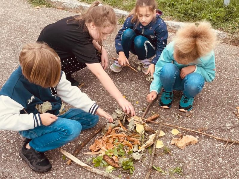 Kinder der 3a beim Legen eines Naturmandalas.