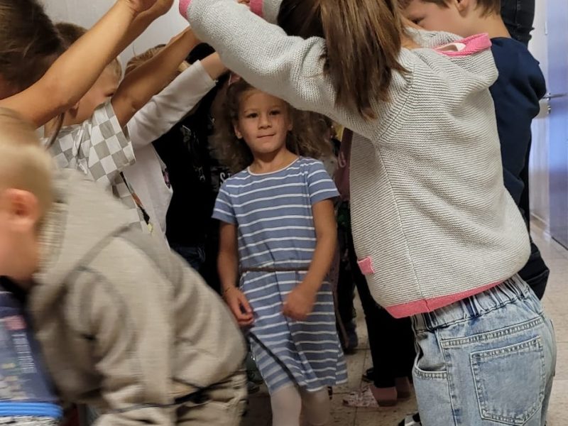 Kinder gehen zur Begrüßung durch ein Spalier.